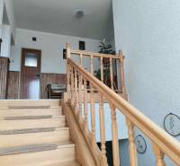 A family house with a wooden staircase, wall cladding, and decoration.