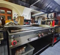Kitchen gastro spaces with stainless steel equipment and a hood.