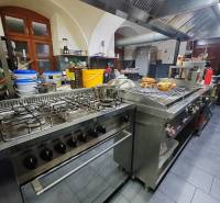Professional kitchen in catering spaces with a stove and a steam extractor.