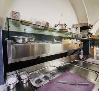 Gastro premises with stainless steel equipment and a preparation area in the room.