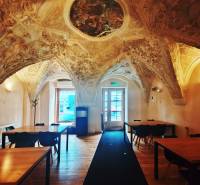 Interior of historic gastro spaces with a vaulted ceiling and a wooden decor floor.