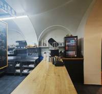 Interior of a gastro space with wood-decor flooring, a worktop, and beverage cooling.