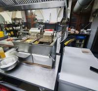 Professional kitchen with a fryer and grill in catering premises.