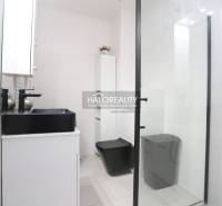 Modern bathroom in a 2-room apartment with black accessories and a shower, elegant design.