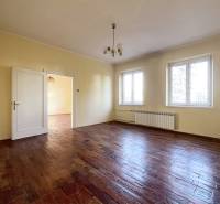 A spacious room with a wooden-decor floor and two large windows.