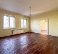 A room with two windows, light-colored walls, and a wooden decor floor in a 5 or more room apartment.