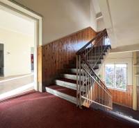 Staircase and entrance to a 5 or more bedroom apartment with a wooden decor floor.