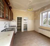 A kitchen in a 5 or more room apartment with tiles, wooden cabinets, a gas stove, and a sink.