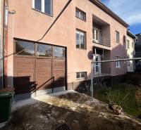 The exterior of the apartment building on Medveckého Street in Ružomberok with a garage and a yard.