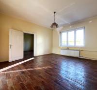A room in a 5 or more bedroom apartment with a wood-patterned floor and large windows.