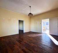 A room with a wooden decor floor and light walls in a 5 or more room apartment.