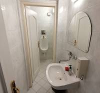 A small bathroom with a sink and a urinal in the offices.