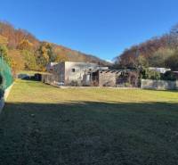 A grassy plot on Karpatská Street in Marianka, surrounded by modern architecture and nature.