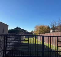 The plot on Karpatská Street in Marianka is surrounded by properties - housing with a green lawn.