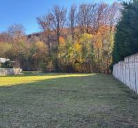 Plots - housing on Karpatská Street, Marianka with a grassy area and trees in the background.