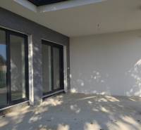 The terrace of a family house in Piešťany with large windows and stone decor.