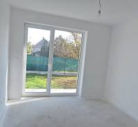 White room with a large window and a view of the garden in a family house.