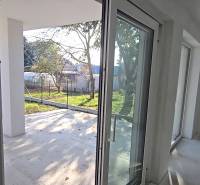 Windows and doors in the family house leading to the terrace, view of the garden.
