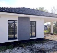 A family house in Piešťany with a white facade, dark roof, and gravel driveway.