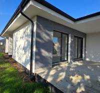 A family house in Piešťany with a terrace and a garden, enclosed by a green fence.
