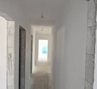 An interior with white walls and a concrete floor ready for finishing in a family house.