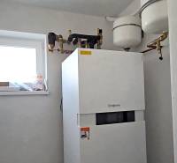 A condensing boiler in a bright utility room of a family house with a window.