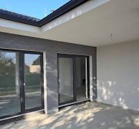 The terrace of a family house in Piešťany with large glass doors and gray walls.