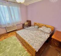 Bedroom in a 4-room apartment with a bed, an armchair, and a wooden decor floor.