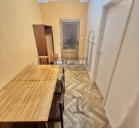 Dining area with a table and chairs on a floor with a wooden decor in a 4-room apartment.