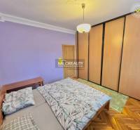 Bedroom in a 4-room apartment with a large built-in wardrobe and a floor with a wooden decor.