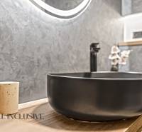 A bathroom in a 2-room apartment with a stylish sink and a decorative wall.