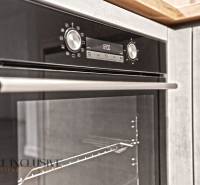 An electric oven in the kitchen of a two-room apartment with a wooden decor floor.