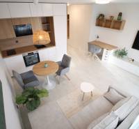 Interior of a 1-room apartment with a kitchen, dining table, and work corner.