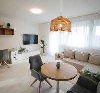 Bright living room with a sofa, coffee table, work corner, and wooden decor flooring.