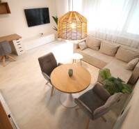 A one-bedroom apartment with a comfortable sofa, a desk, and a wooden decor floor.