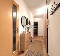 A hallway in a 2-room apartment with wooden decor, a mirror, and a coat rack.