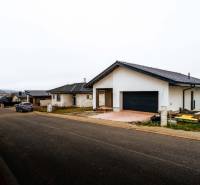 A family house in Stará Ľubovňa with a parked car in front of the garage on a quiet street.