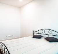 Bedroom of a family house with a metal bed and a floor with a wooden decor.