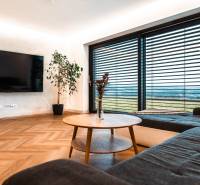 A living room in a family house with a large television, a wooden table, and a floor with a wooden decor.
