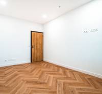 A spacious room in a family house with a wooden decor floor and distinctive wooden doors.