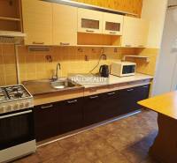 A kitchen in a 3-room apartment with a gas stove and a wooden decor floor.