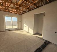 The interior of a family house with exposed ceiling beams and electrical installation preparation.