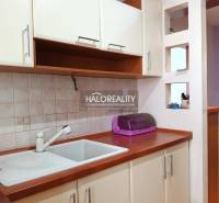 Kitchen corner in a studio apartment with a sink and cabinets.