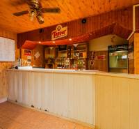The interior of a family house with a booth and wooden paneling at the bar.