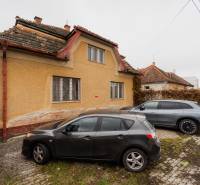 A family house on Partizánska Street in Bánovce nad Bebravou with two cars parked in front of it.