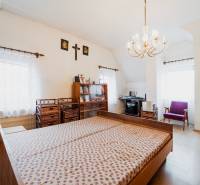 Bedroom in a family house with wood-patterned flooring, a bed, and a workspace.