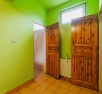 Green walls, wooden doors, and tiled floor in a family house.