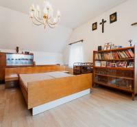 Bedroom in a family house with wood-decor flooring, a bookshelf, and a chandelier.