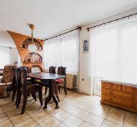 Dining area in a family house with wooden decor on furniture and shelves.