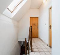 A hallway with a skylight and light walls in a family house, wooden railing, cladding.